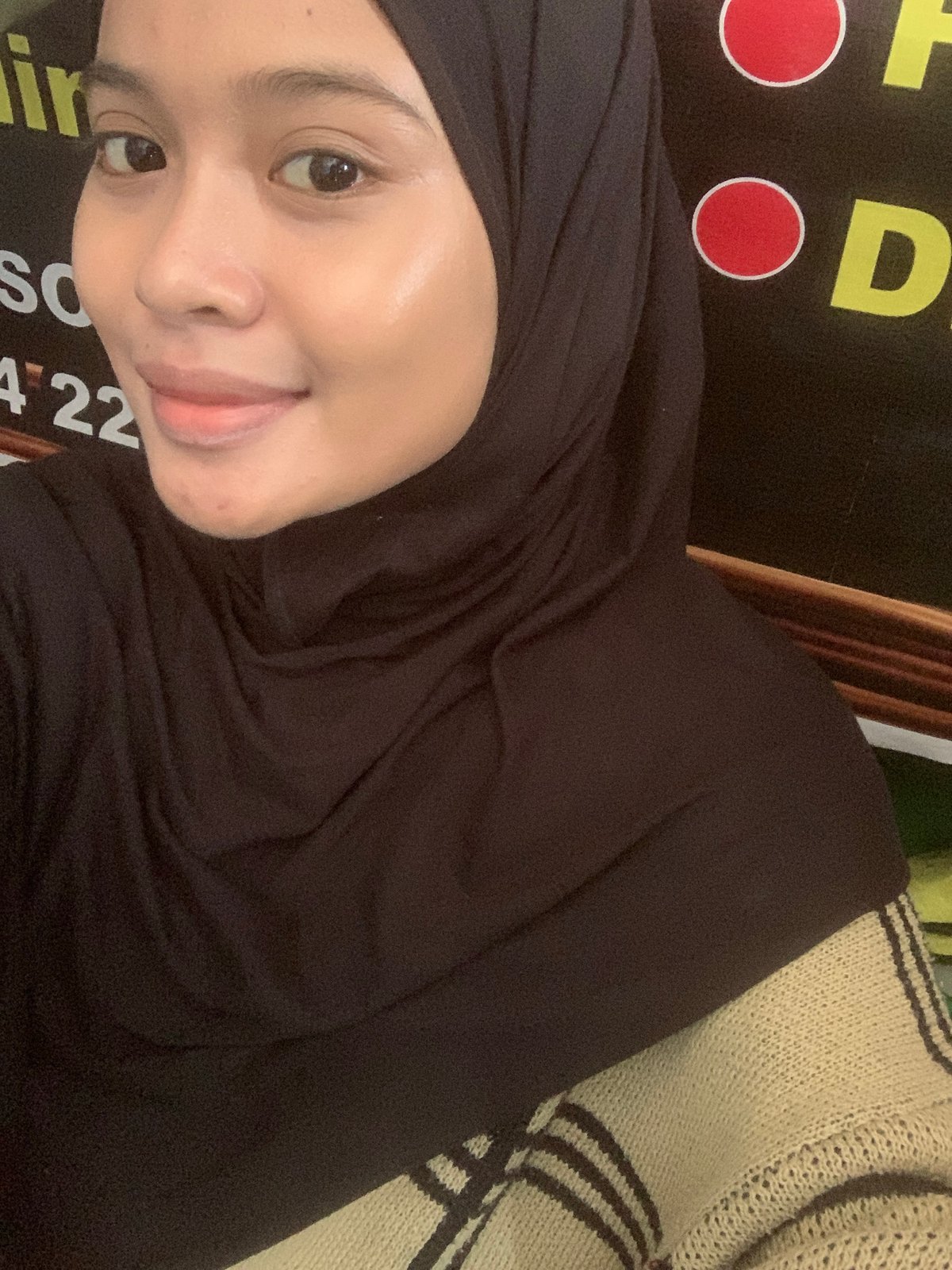 Selfie session in Sungai Meriam, dark hijab, signage backdrop