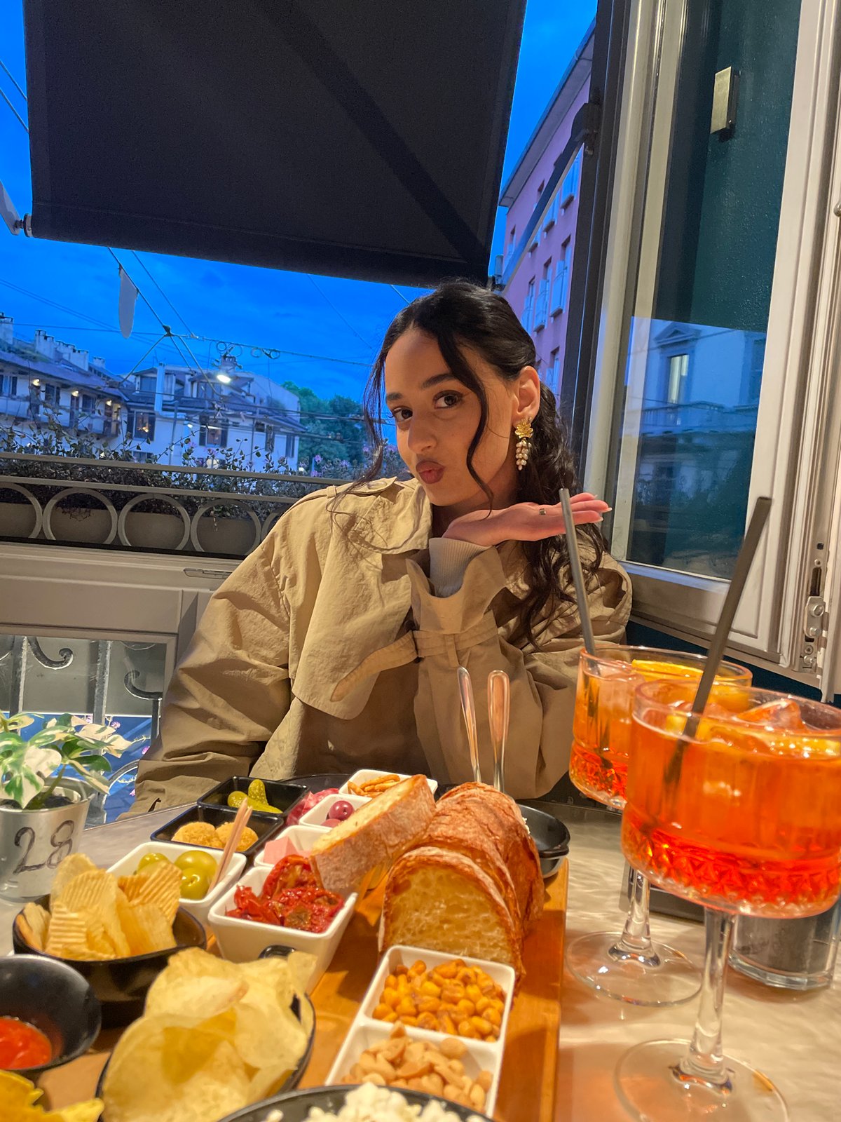 Woman documents aperitivo hour with cocktails in Milan