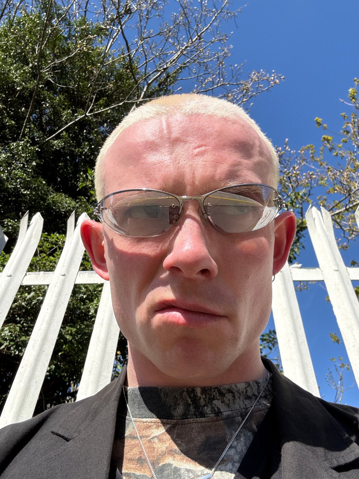 Man in sunglasses photographed near fence, filmed on London transport