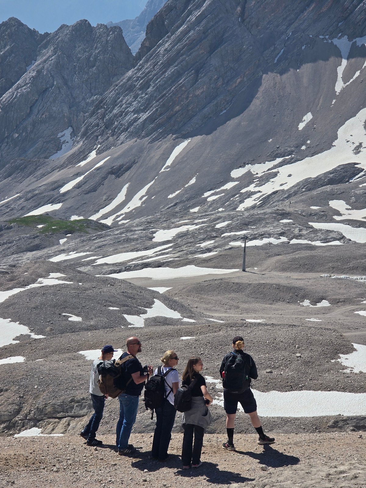 Hikers and snow groomers on a clear morning in the Bavarian Alps