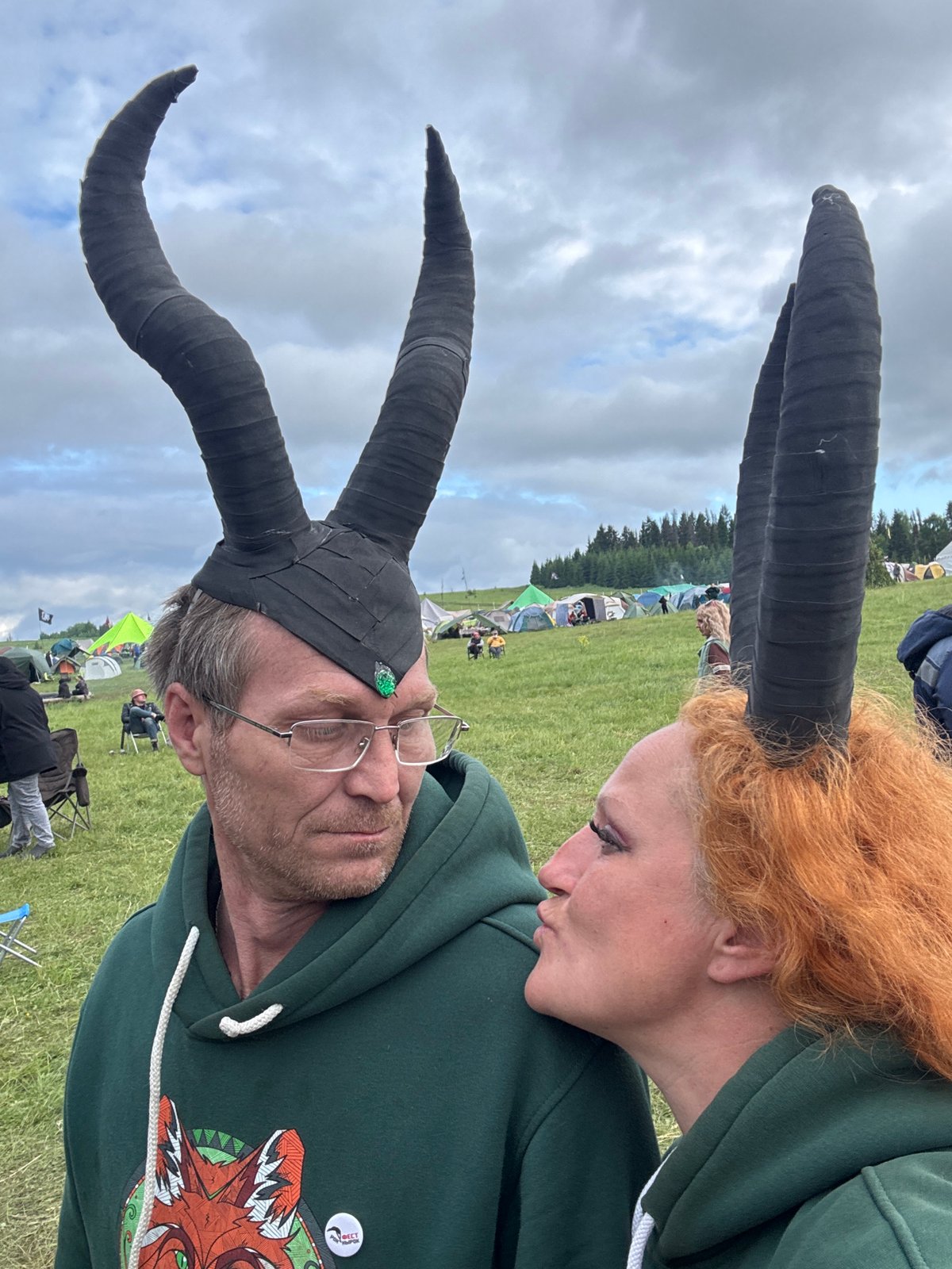Two people interact in Russian field under overcast skies
