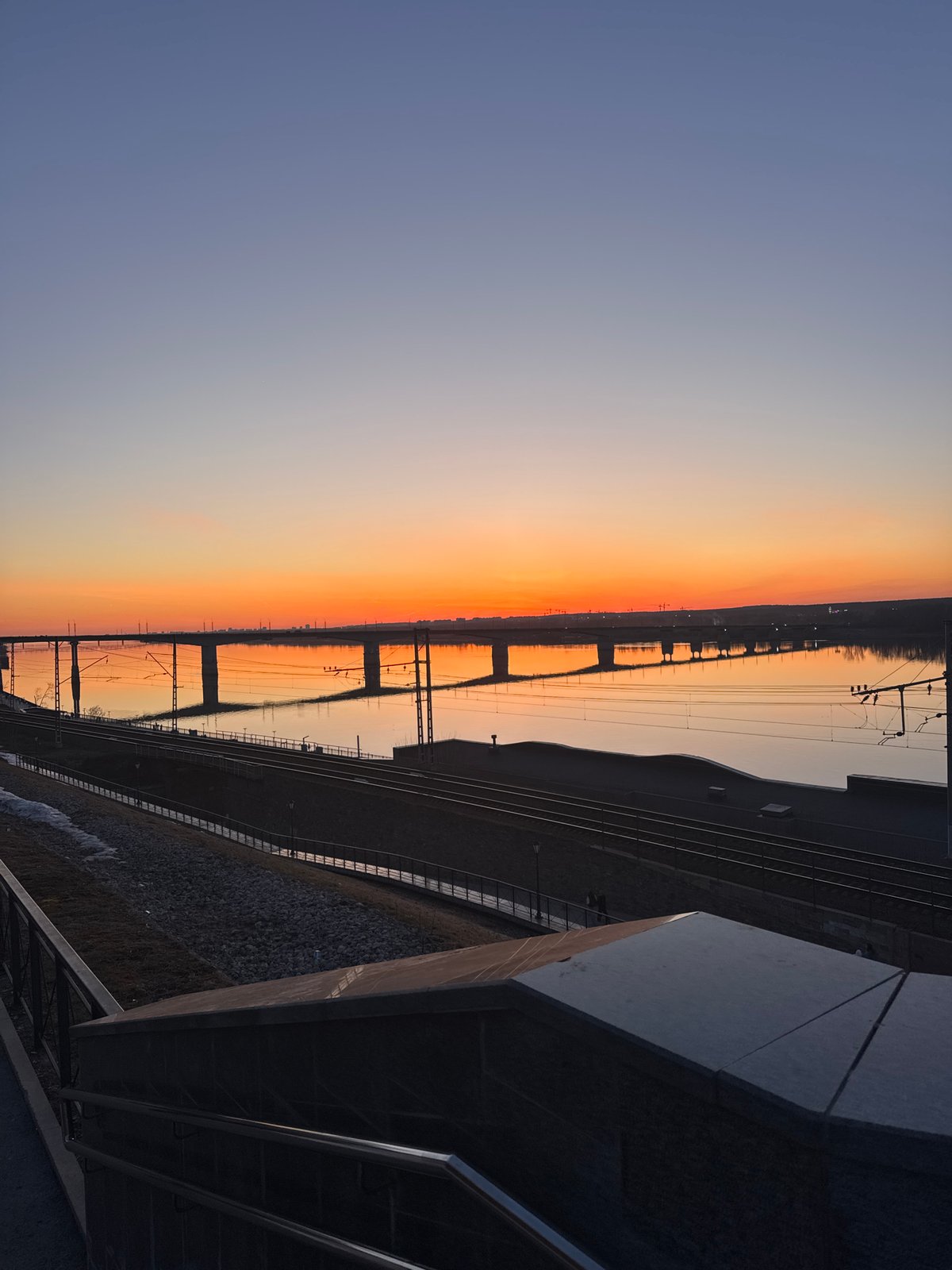 Sunset illuminates railway bridge over Kama River in Perm