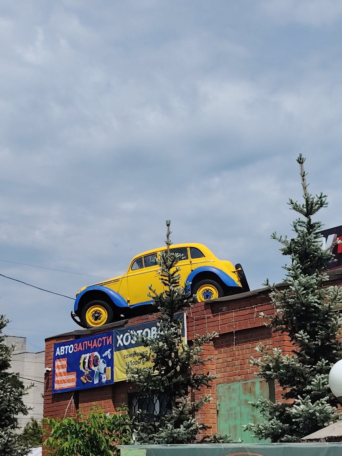 Vintage car serves as rooftop advertisement for autoparts shop