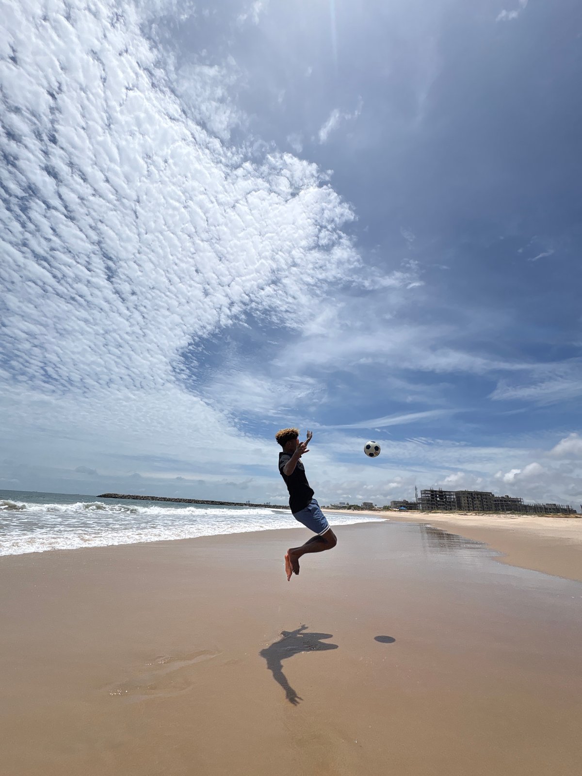 Soccer player practices ball juggling on Nigerian beach
