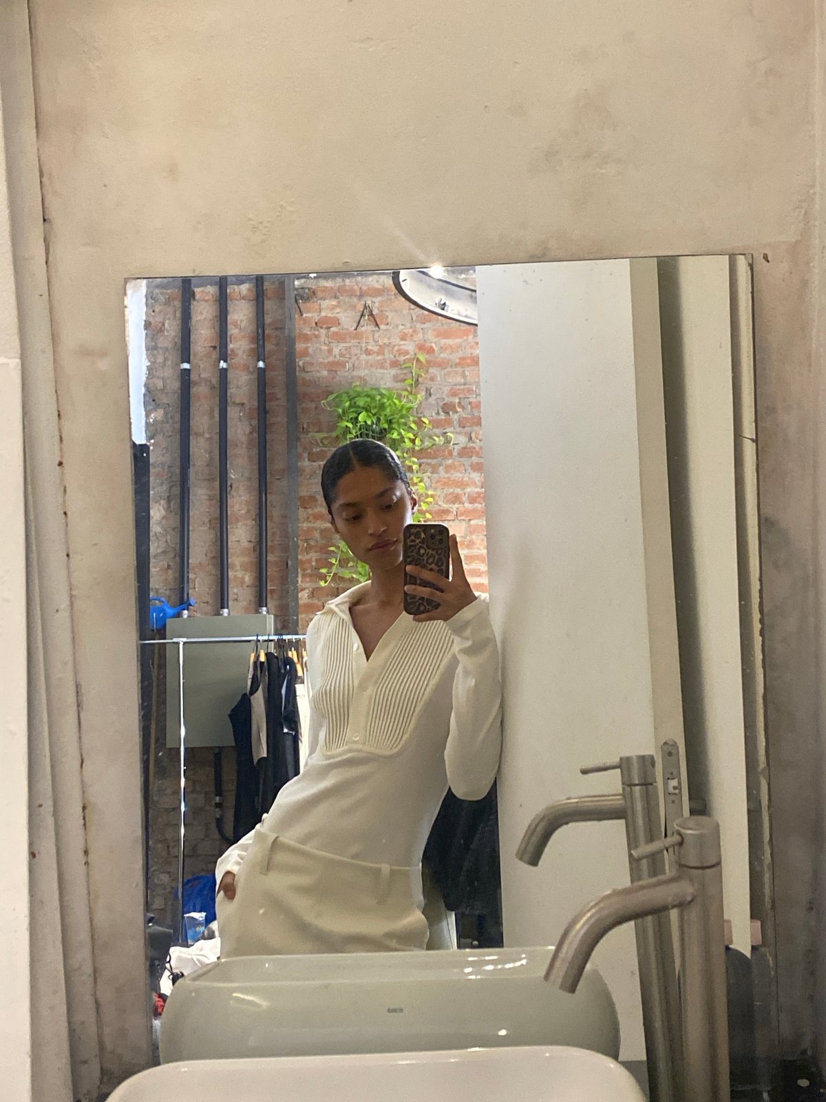 Person takes mirror selfie in São Paulo clothing store