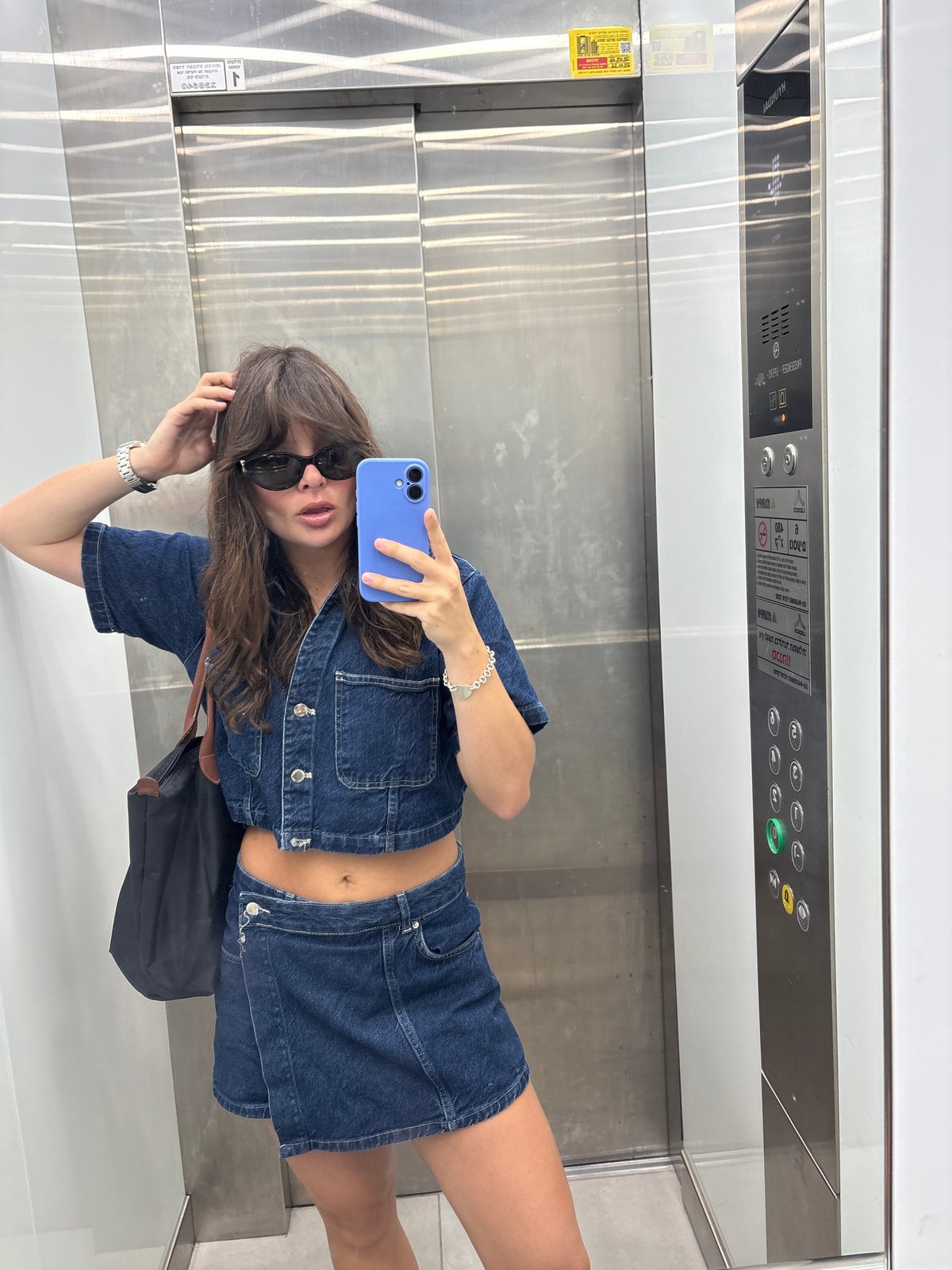 Elevator mirror selfie in Tel Aviv, denim outfit.