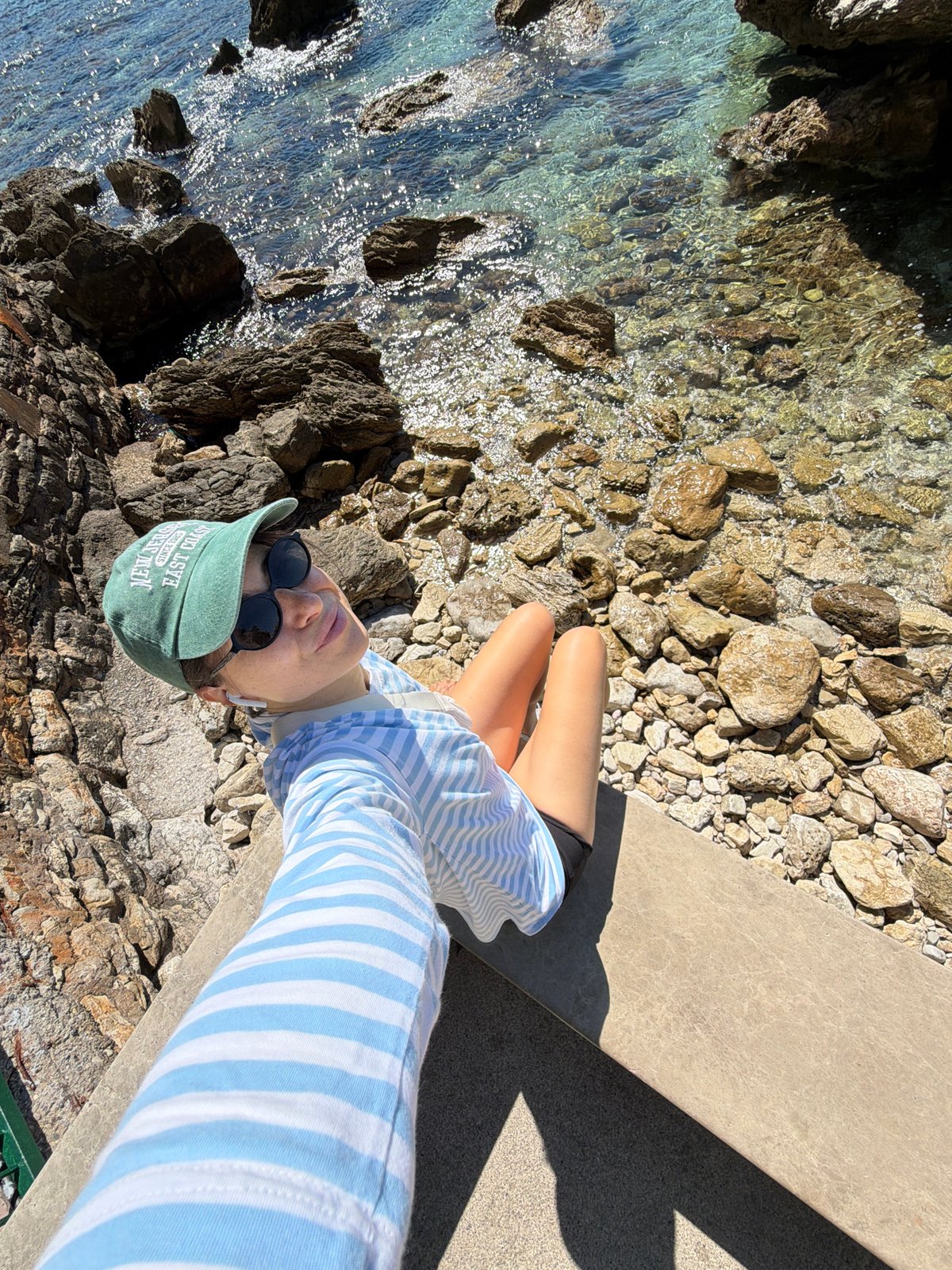 Tourist captures seaside selfies along Budva's rocky Montenegro coastline