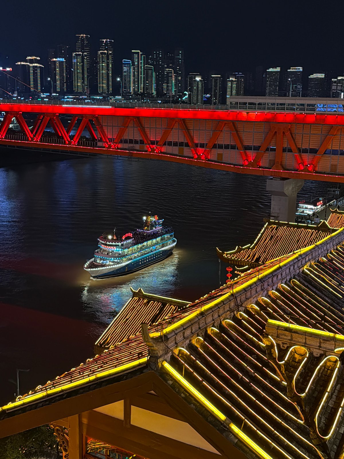 Illuminated cruise ships navigate Chongqing rivers amid street activity