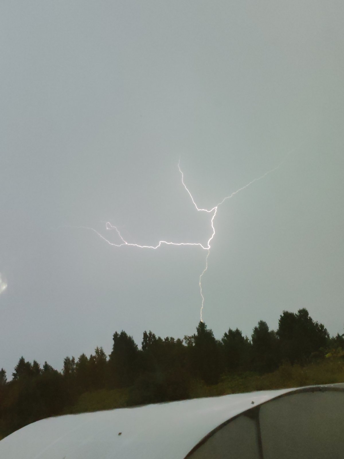 Summer storm rolls through a rural Russian camp, lightning included