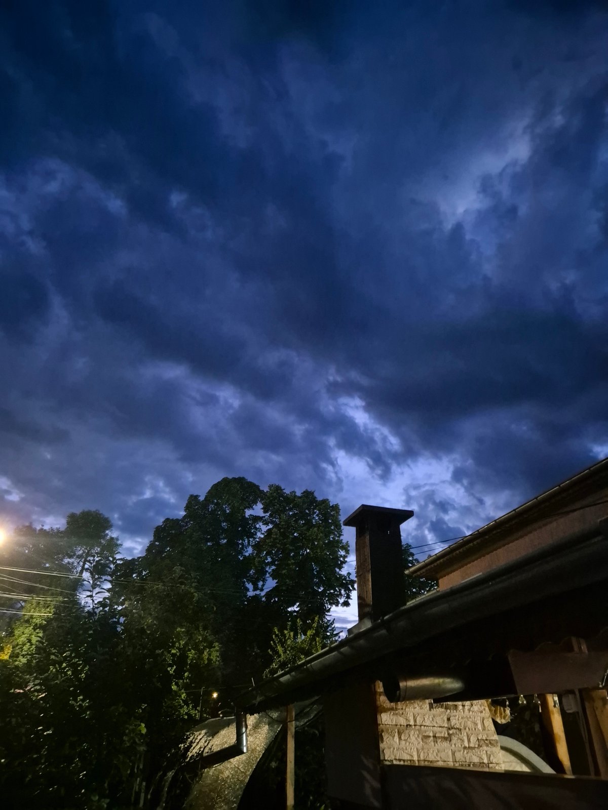 Evening backyard hangout with fruit trees and a stormy sky