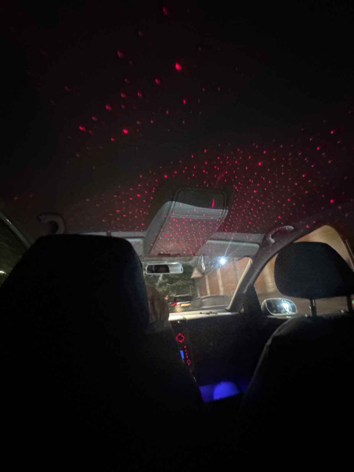 Red laser lights turn a car ceiling into a starry night