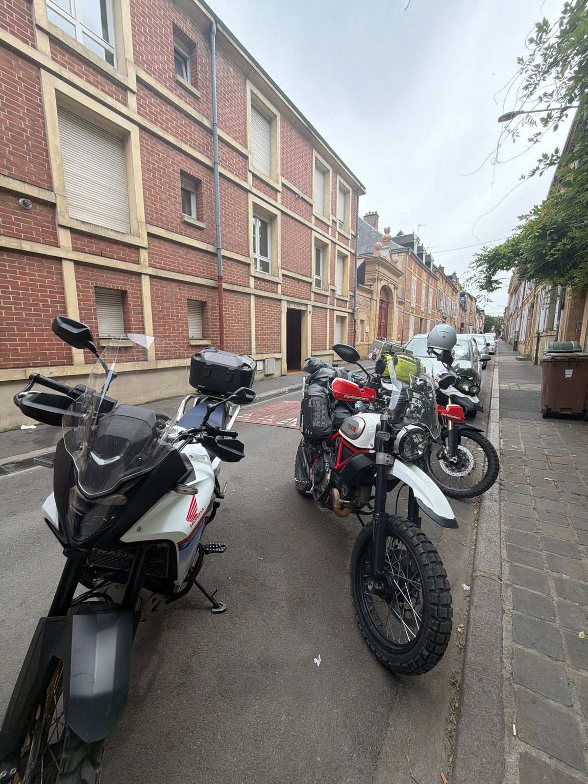 Motorcycles parked on cobblestone street in Charleville-Mézières