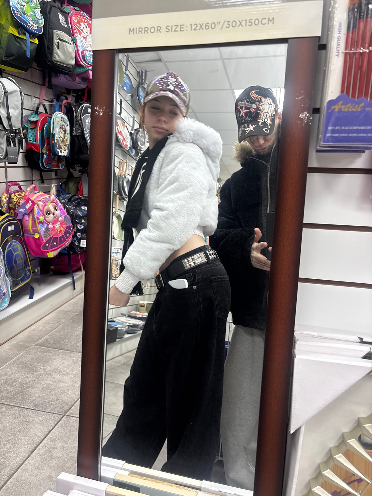 Young shopper takes mirror selfies in Buenos Aires stores