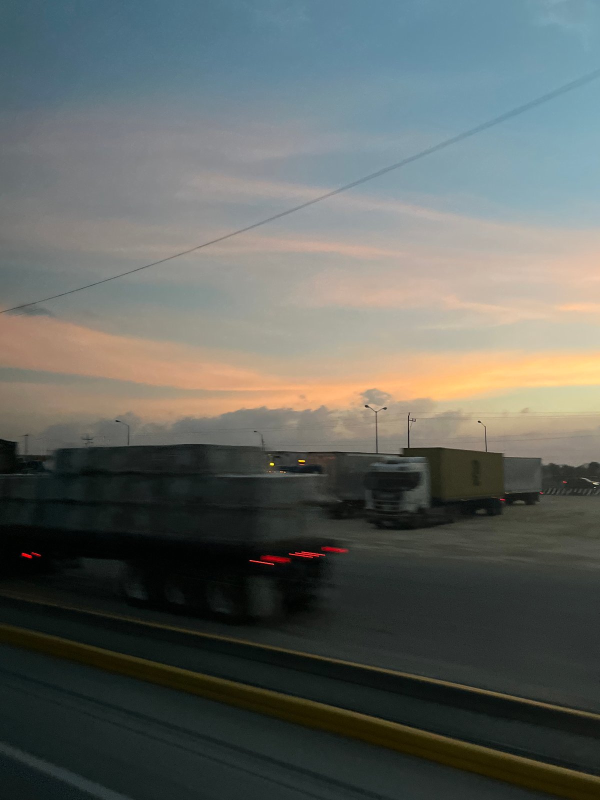 Semi-trucks lined highway at dusk in Mexico