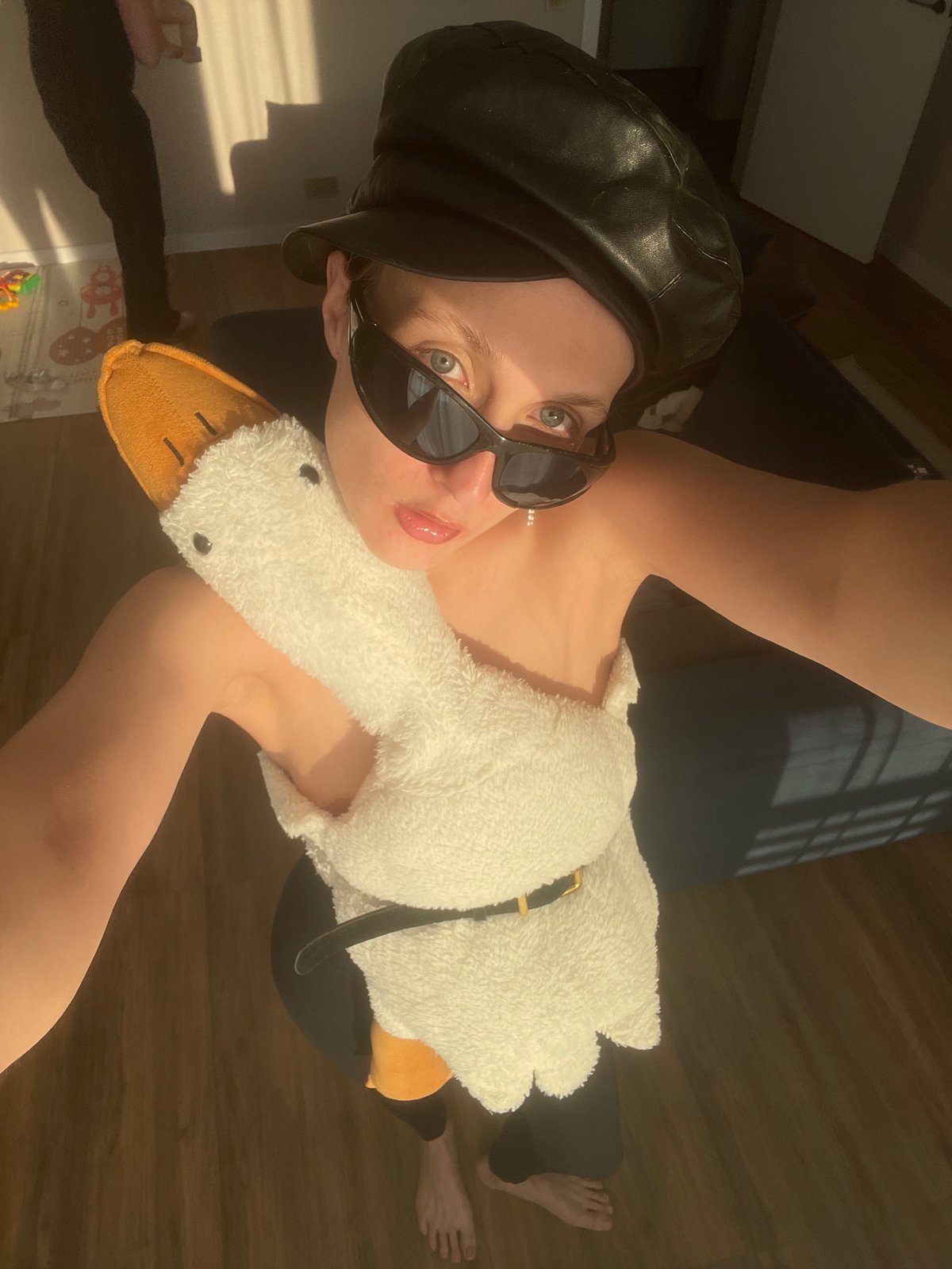 Person poses with plush goose indoors in Russian village