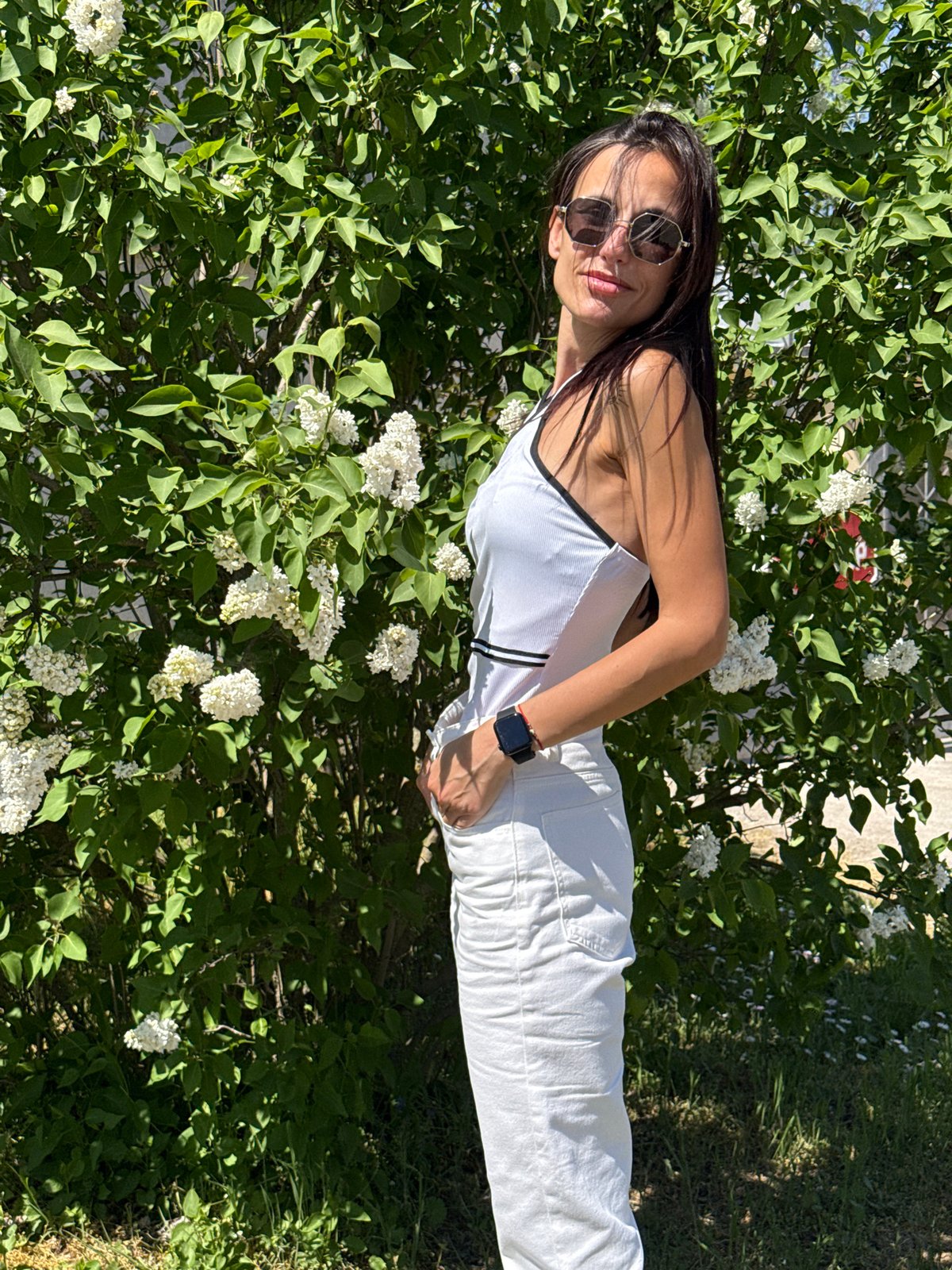 Woman poses for photo near lilac bush in Pleven