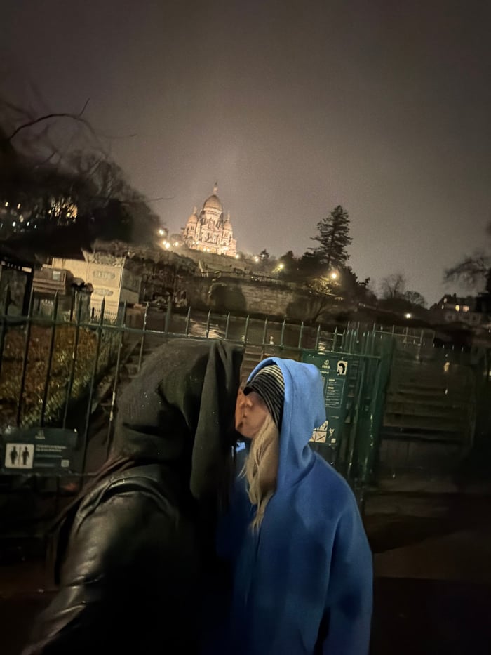 Hooded couple documented across Paris locations in evening photo series