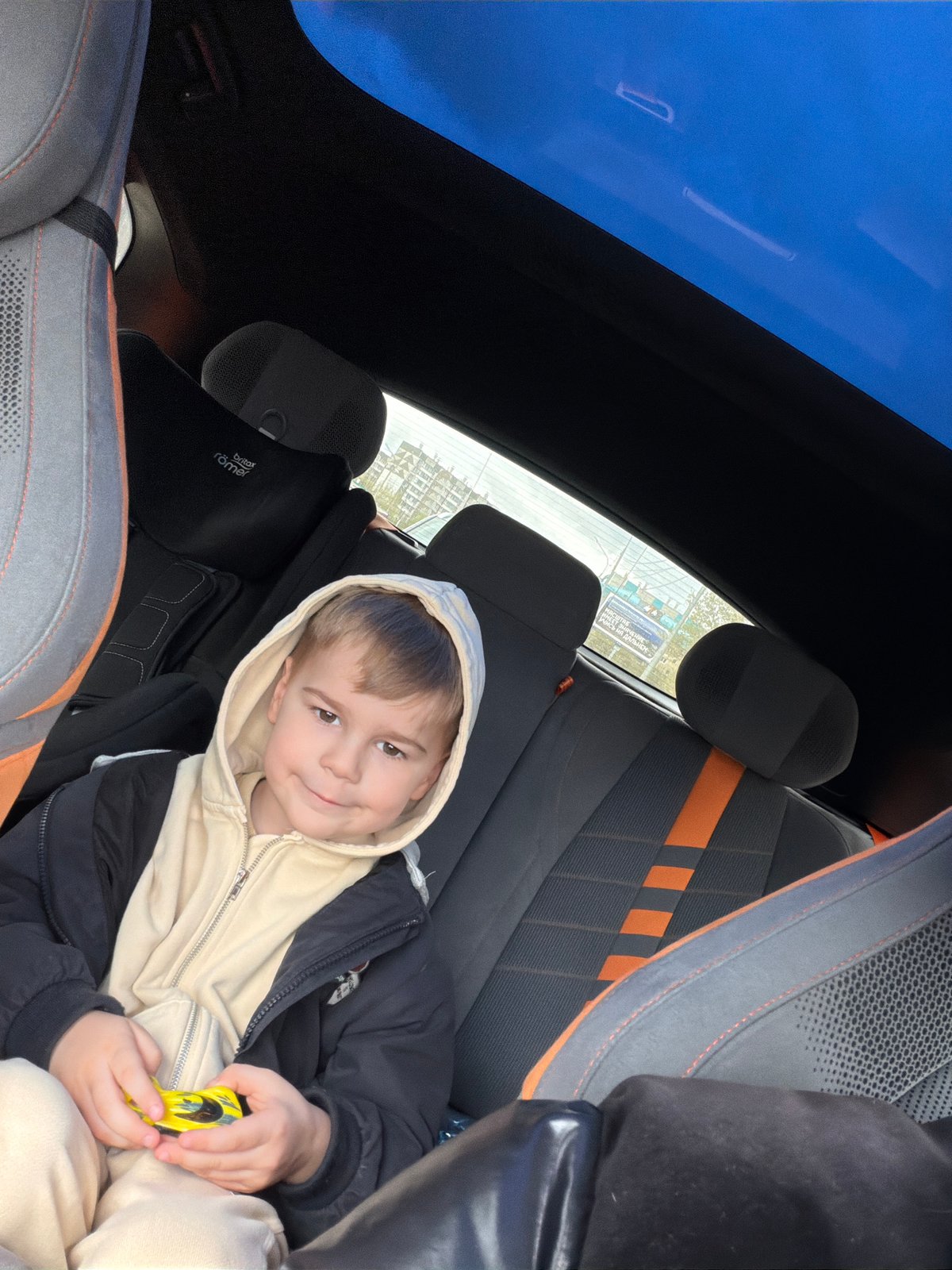 Boy sits in car with sunroof in Krasnoyarsk