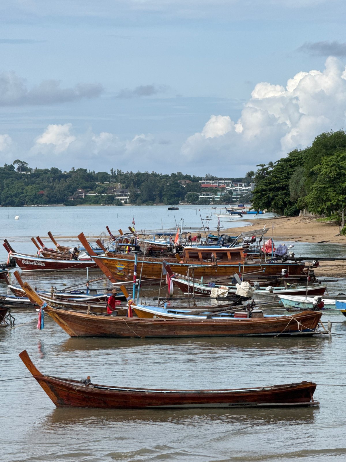 Longtail boats and a mosque along Rawai's quiet shoreline