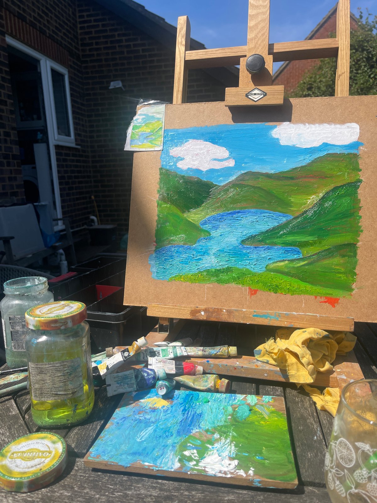 Artist paints waterfall landscape outdoors in Maidstone backyard