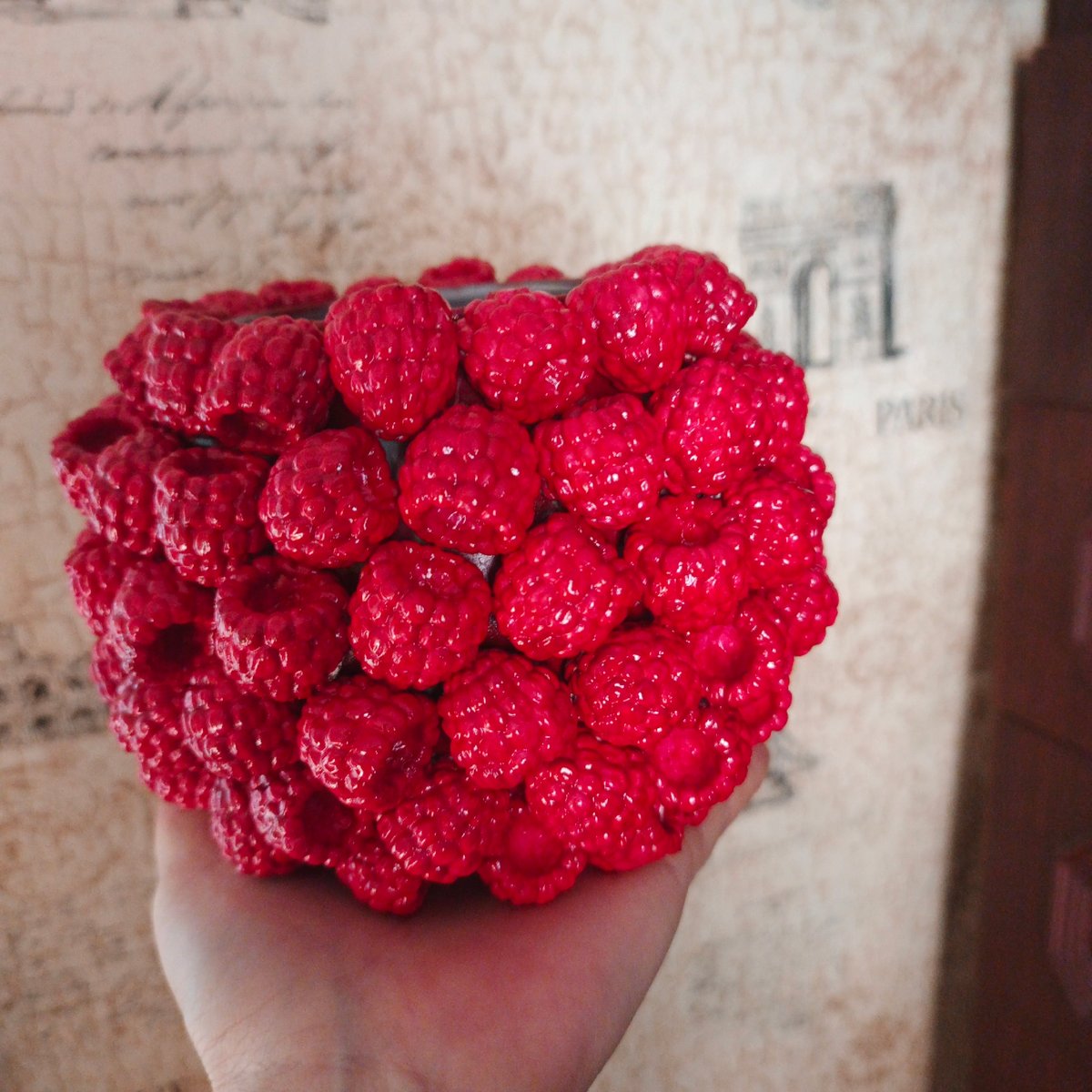 Holding a bright red raspberry-shaped plastic object in Russia