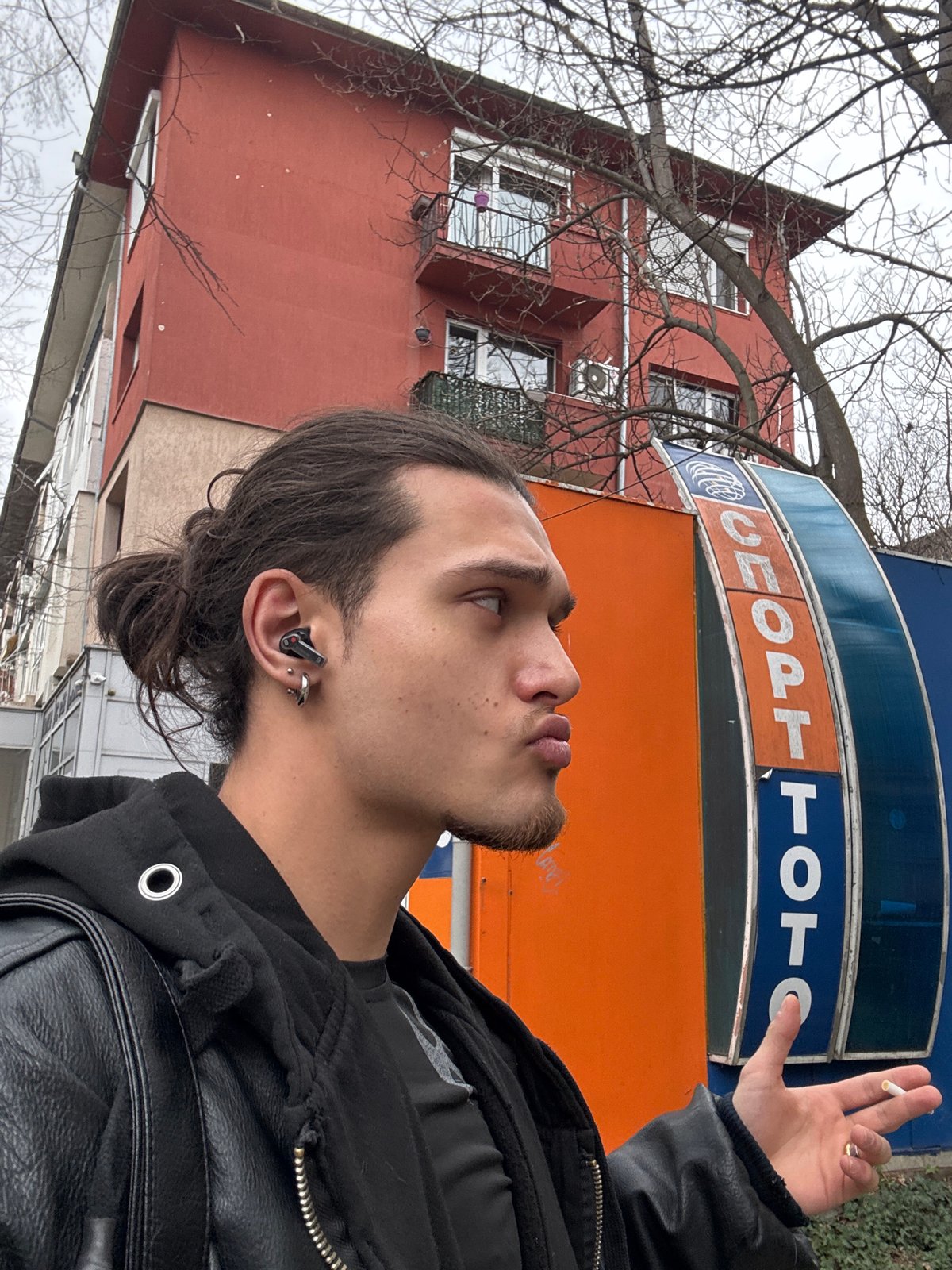 Man smoking cigarette outside Sport Toto building in Sofia