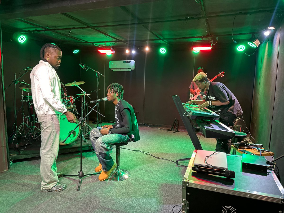 Band rehearses in a Nigerian studio under colored stage lights