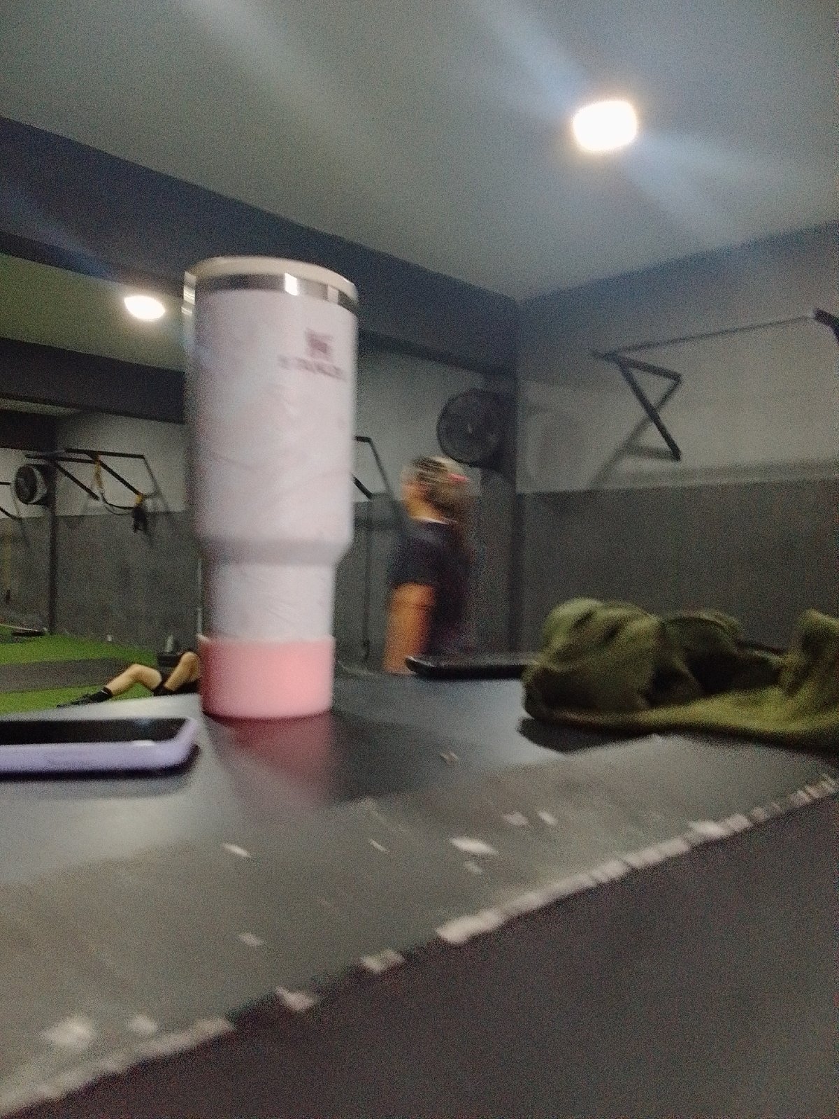 Gym gear laid out: tumbler, phone, workout in progress