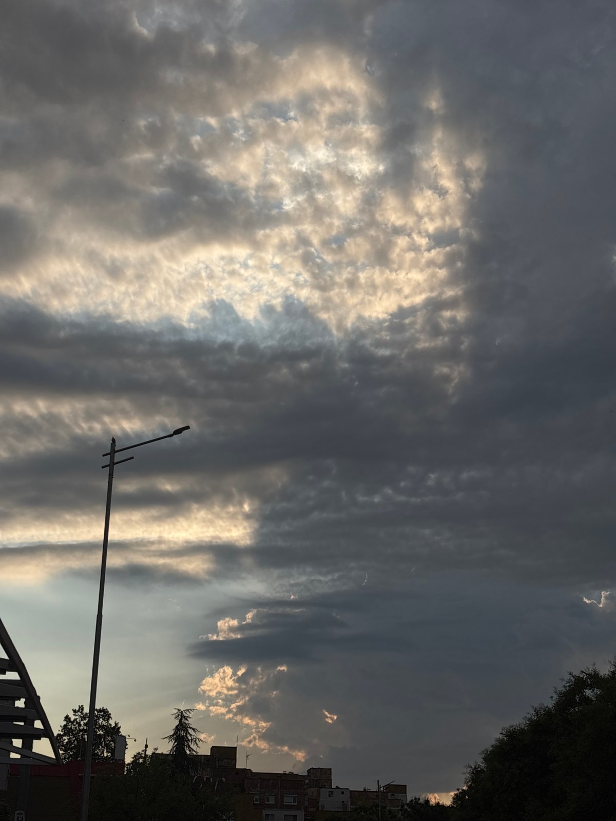 Golden rays break through storm clouds over city streets
