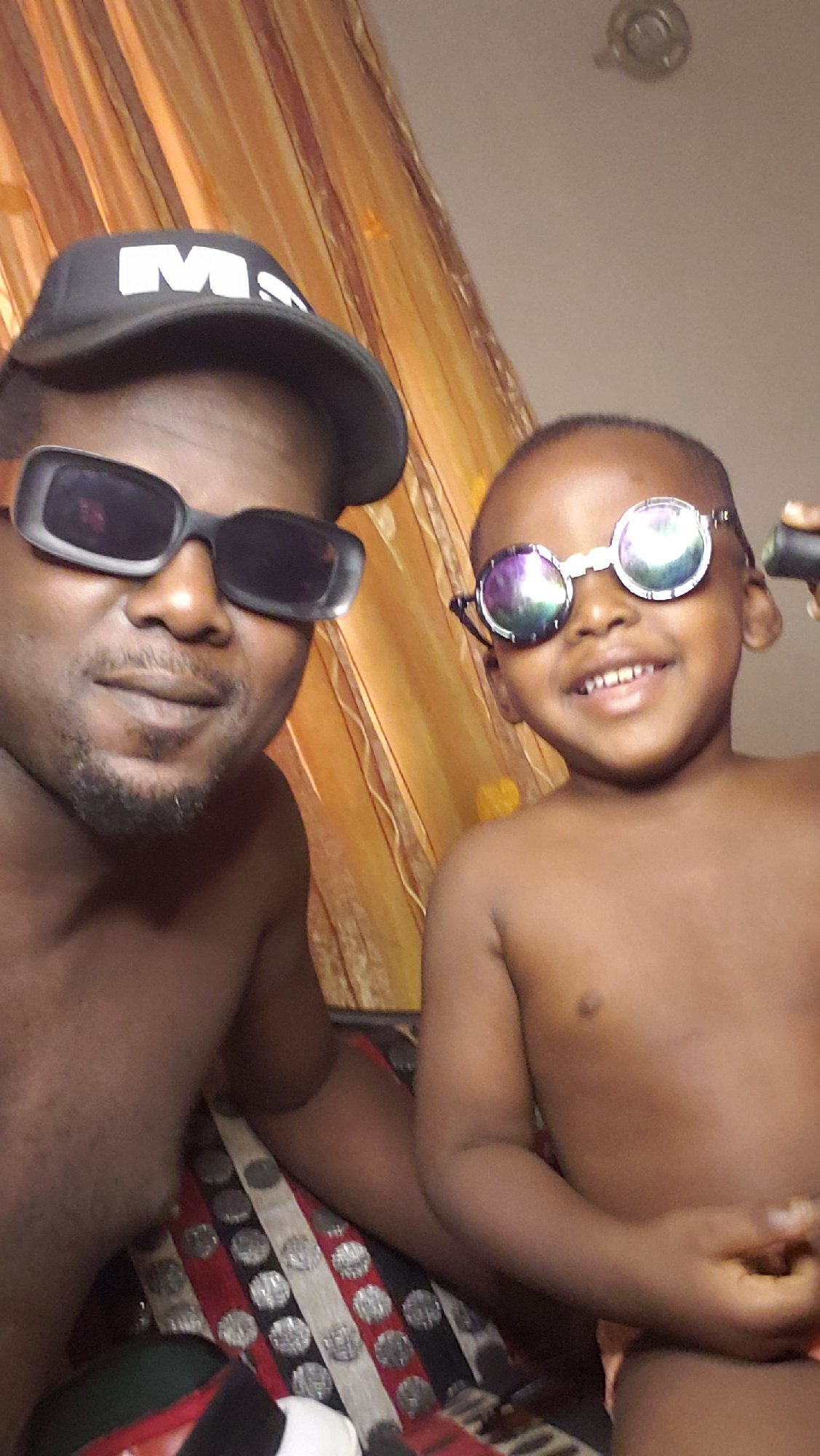 Father and child share playful indoor moments in Nigeria