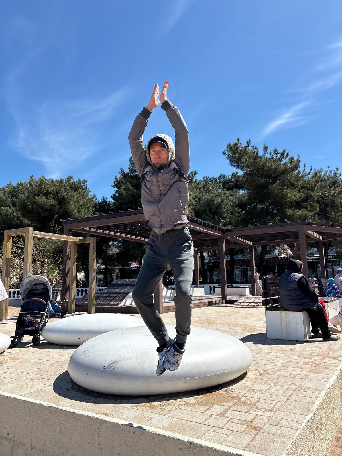 People perform jumping poses at Gelendzhik beach promenade