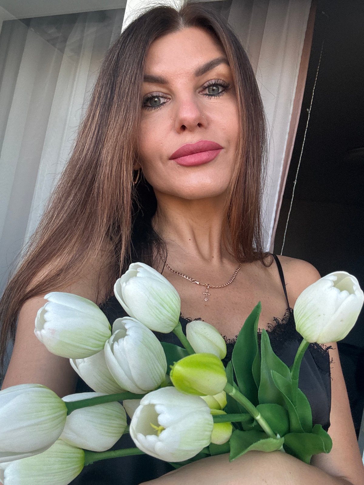 Woman with white tulips observed in Chaikovsky, Russia