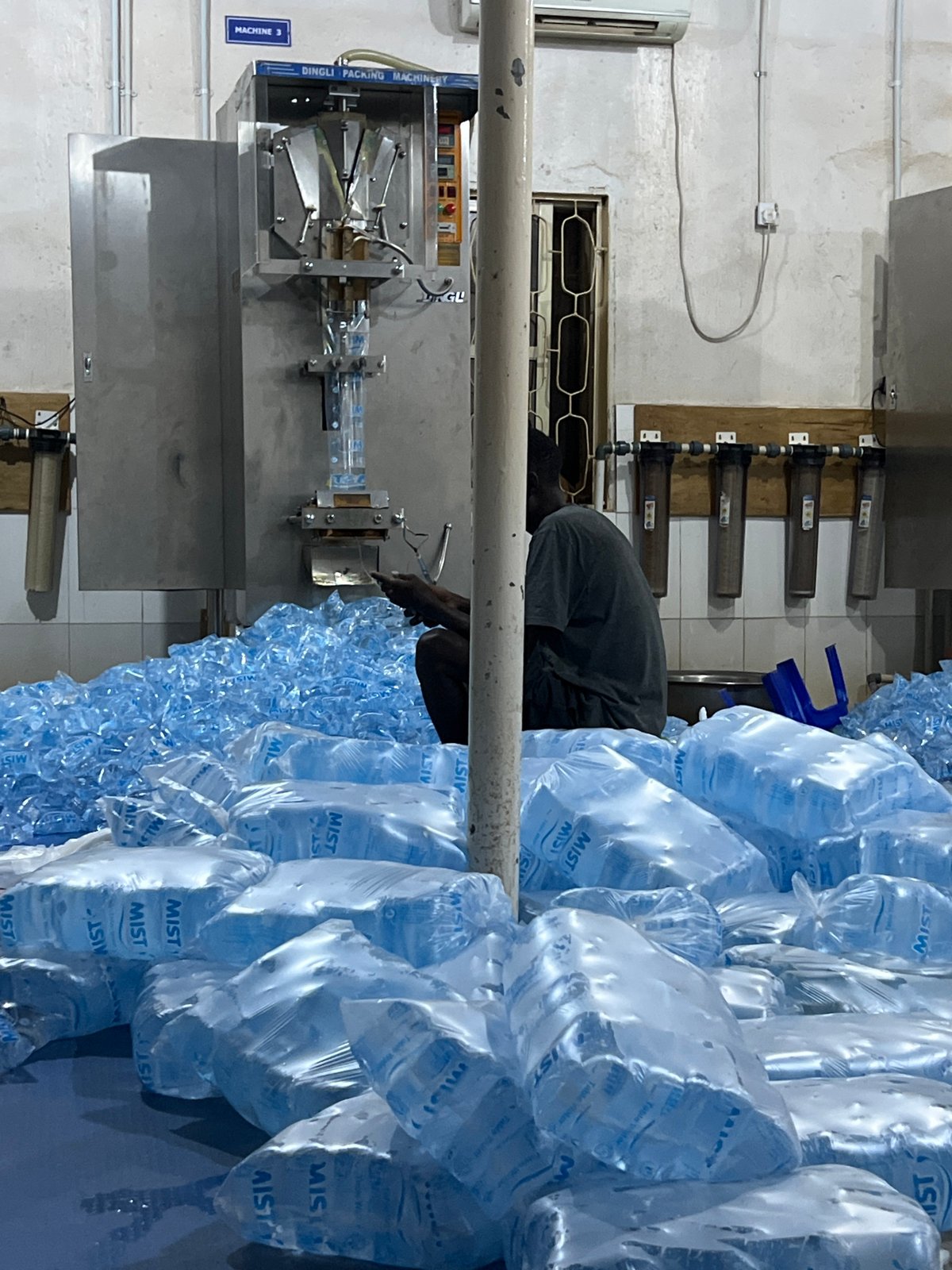 Workers package water sachets at Jos bottling facility