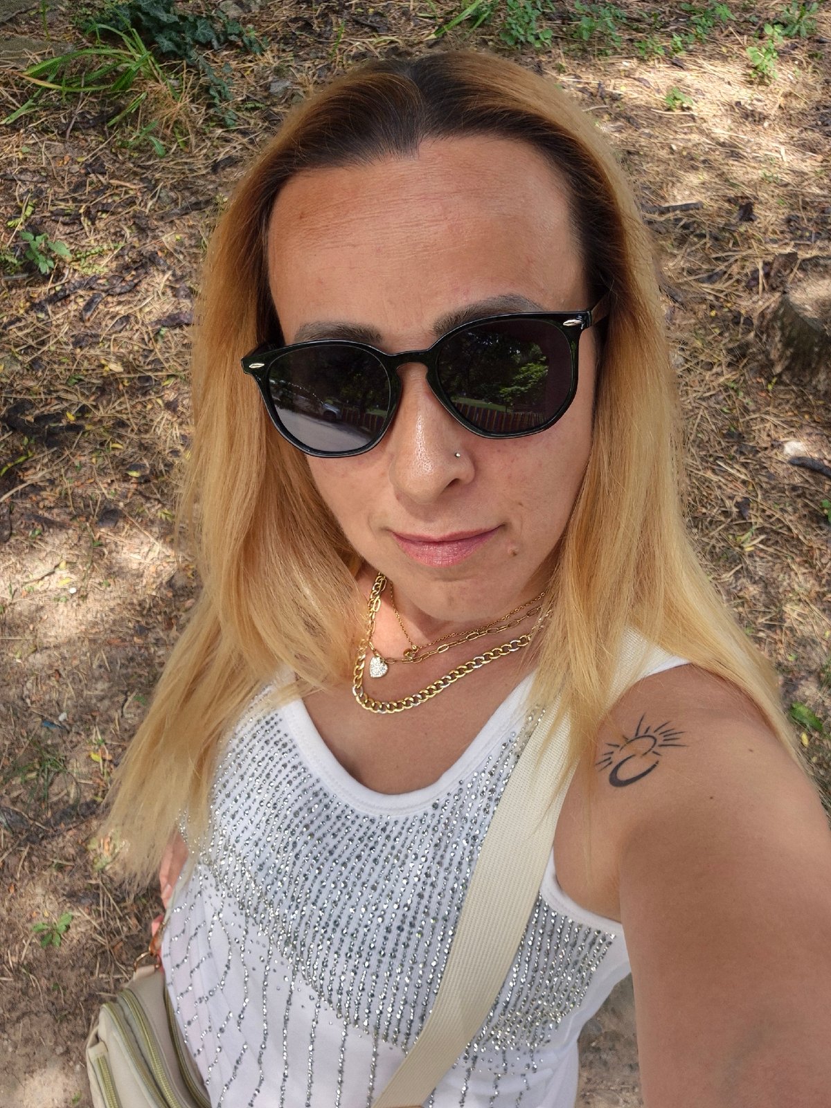 Overhead outdoor selfie, sunglasses and silver sequin top.