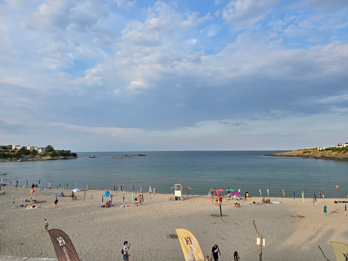 Crowded beach, evening event, and solo fishing near rocky shore