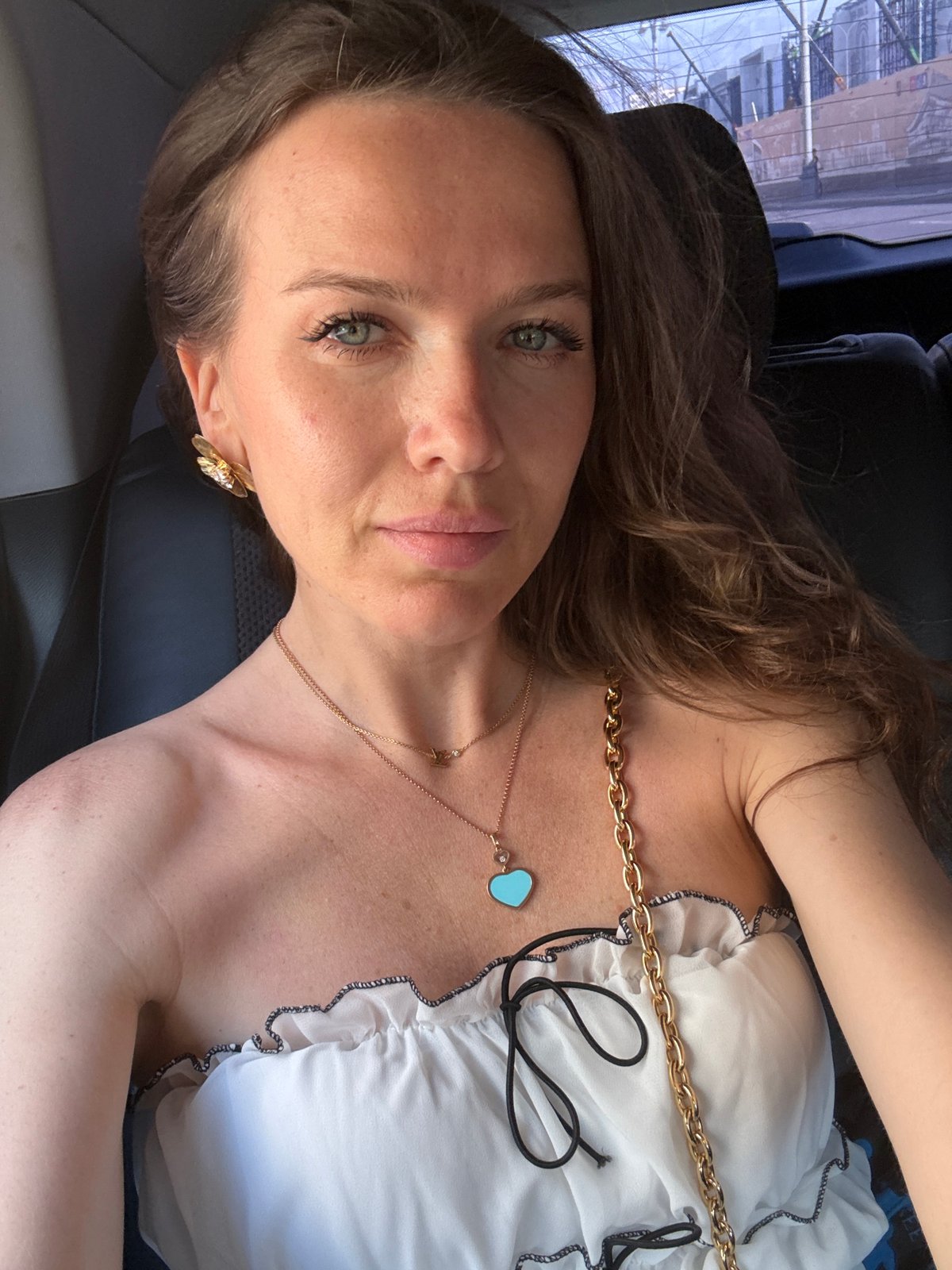 Woman takes selfie wearing gold jewelry in Moscow