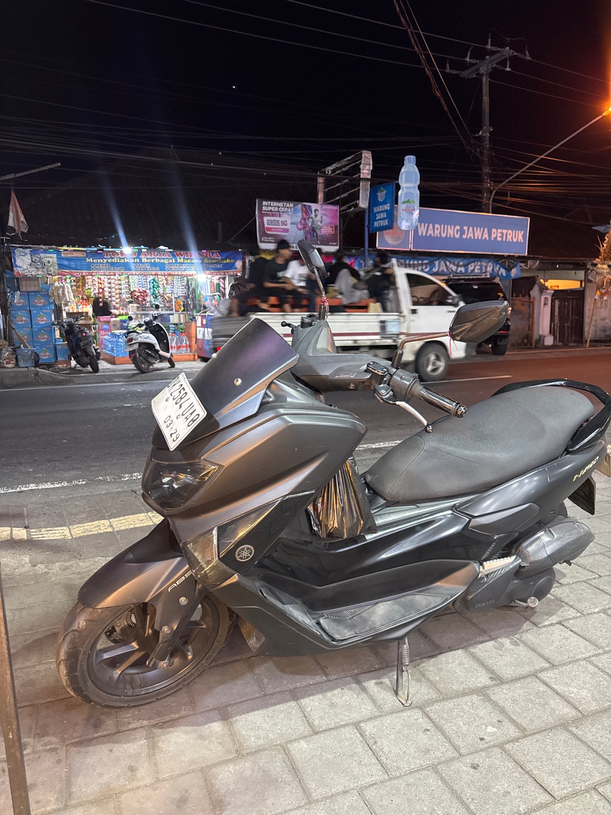 Nighttime street scenes around a Denpasar commercial strip