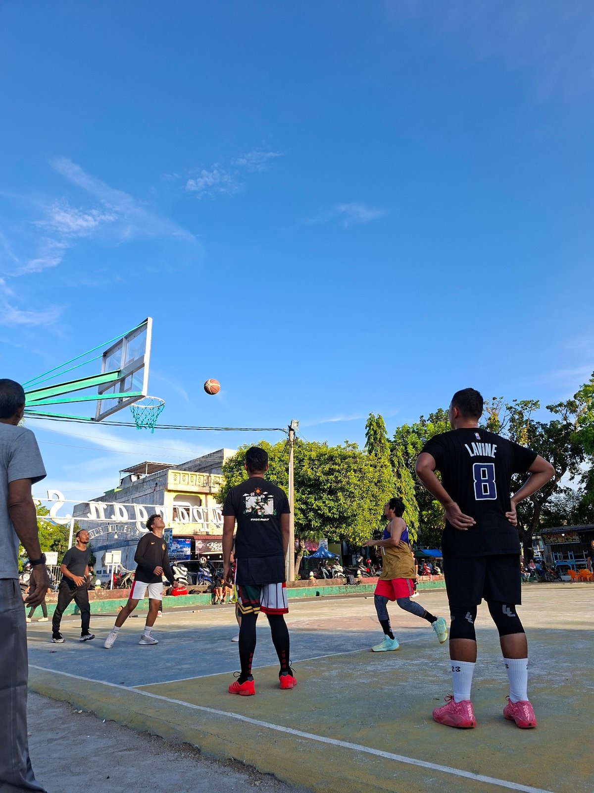 Daily life unfolds in Lhokseumawe: basketball, motorcycles, traffic