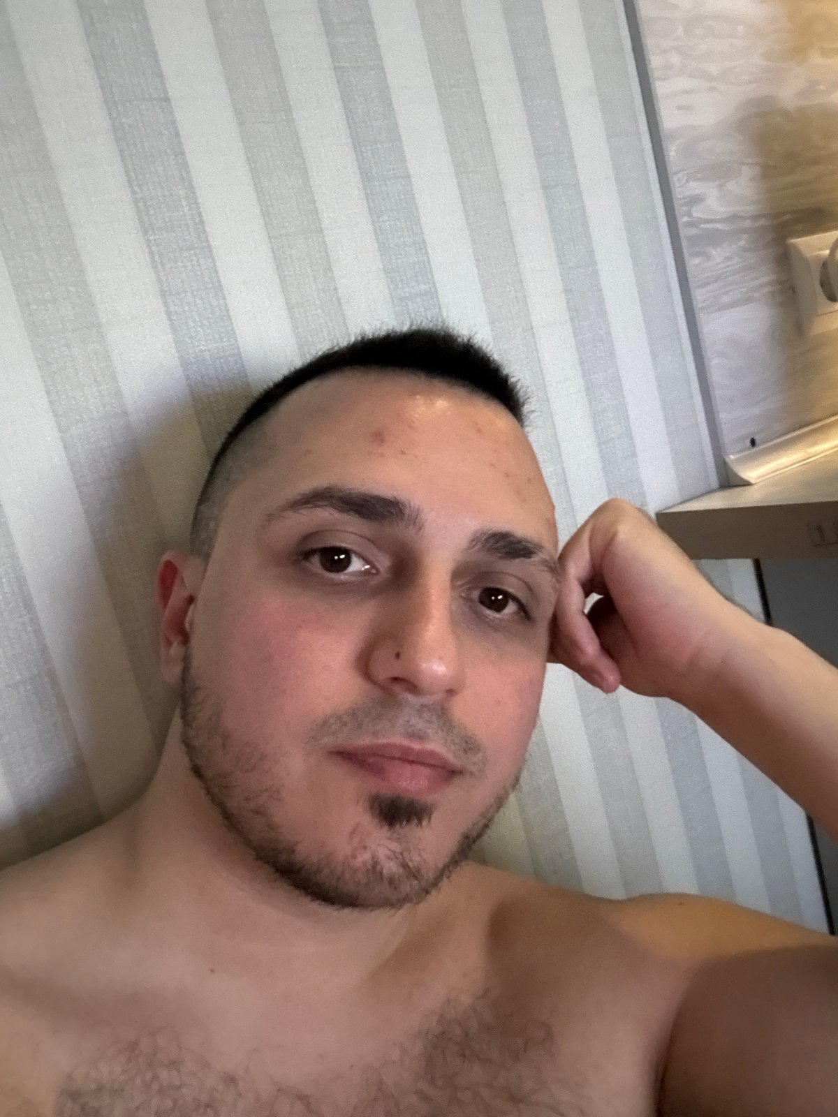 Young man takes indoor selfies from multiple angles