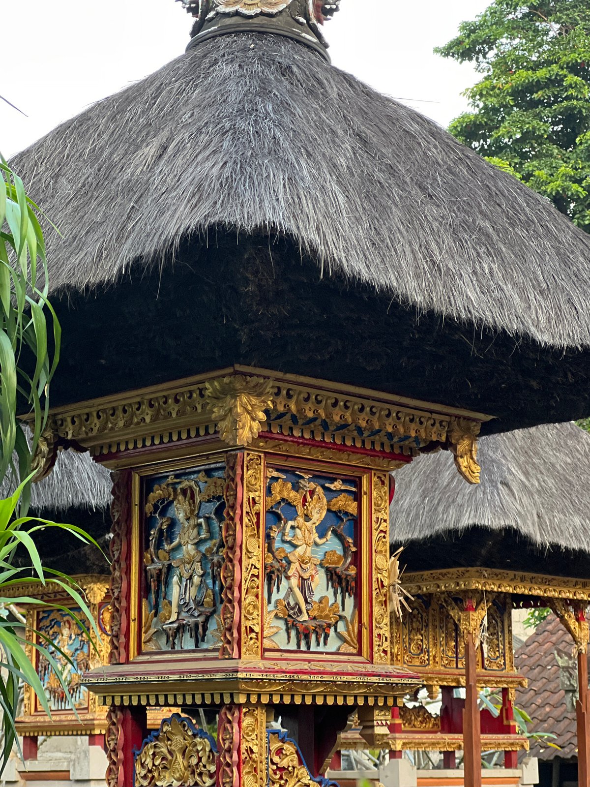 Cat rests on stone ledge near traditional architecture in Ubud