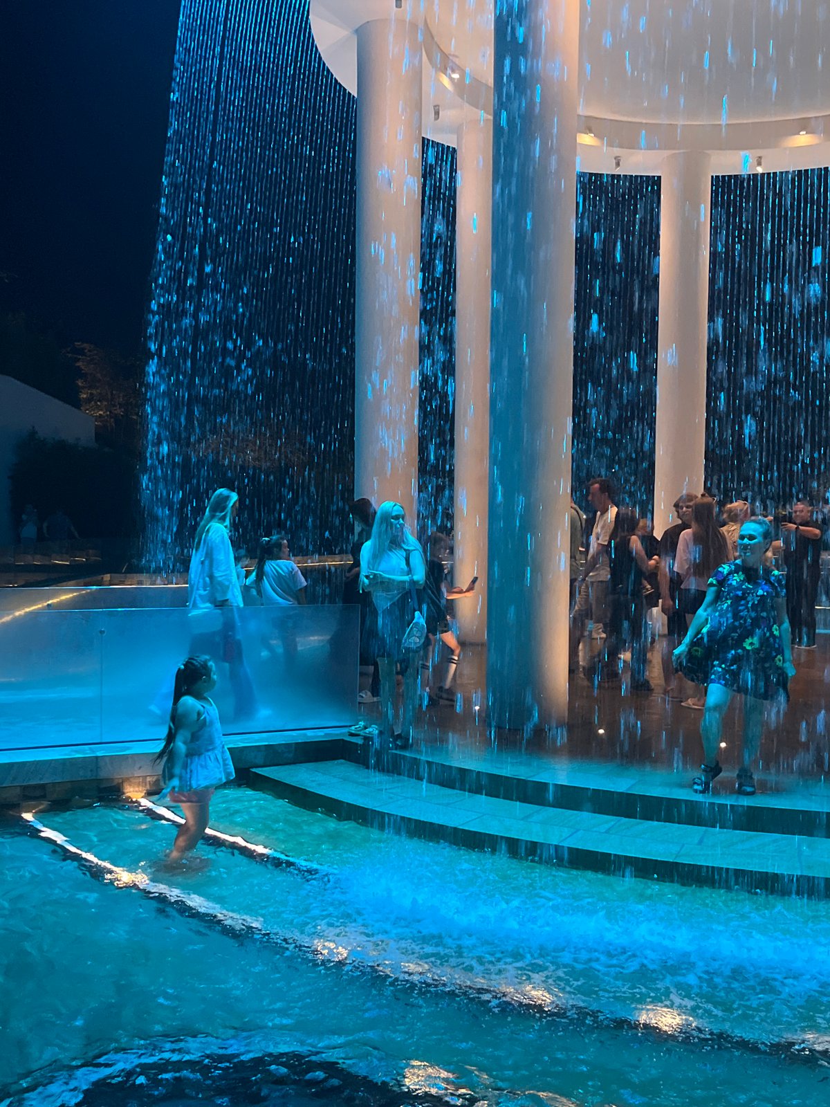 Evening crowds fill a lit modern plaza in Krasnodar