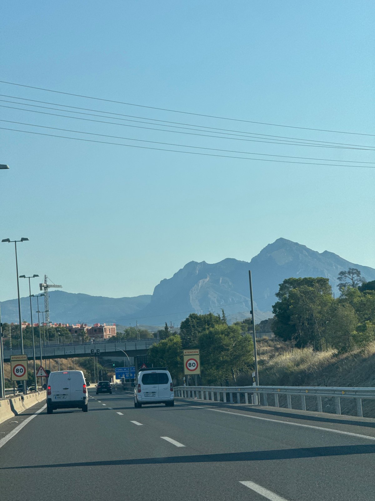Open highway cuts through dramatic mountain scenery near Lloixa
