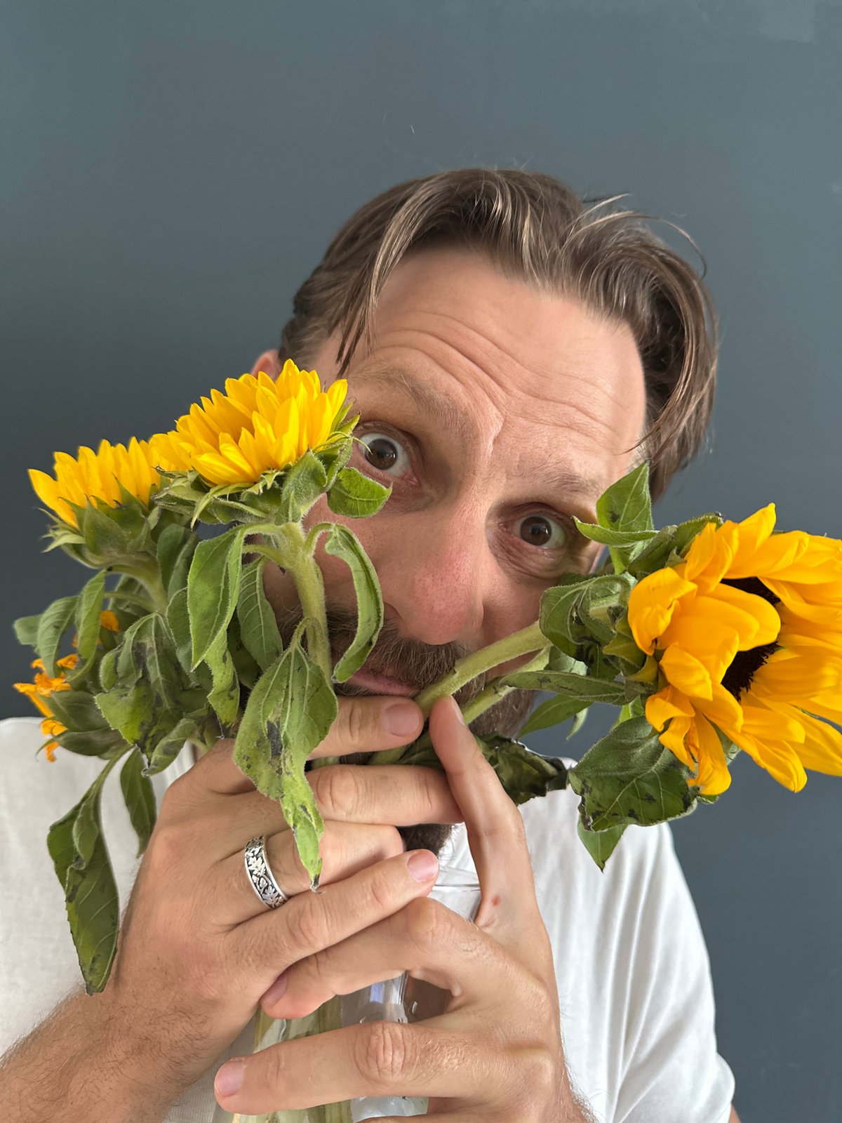 Man photographed in casual portraits with sunflowers in Fethiye