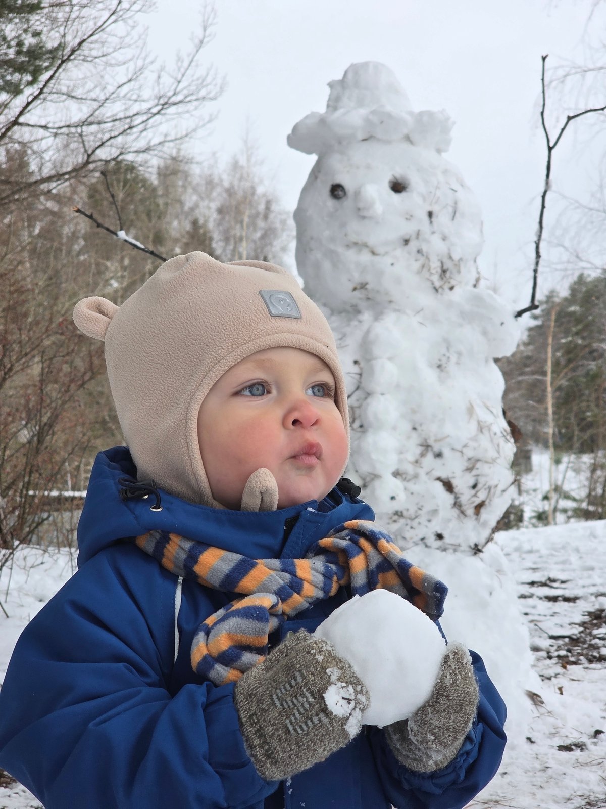 Child plays in snow, dog gets treats in Chaikovsky