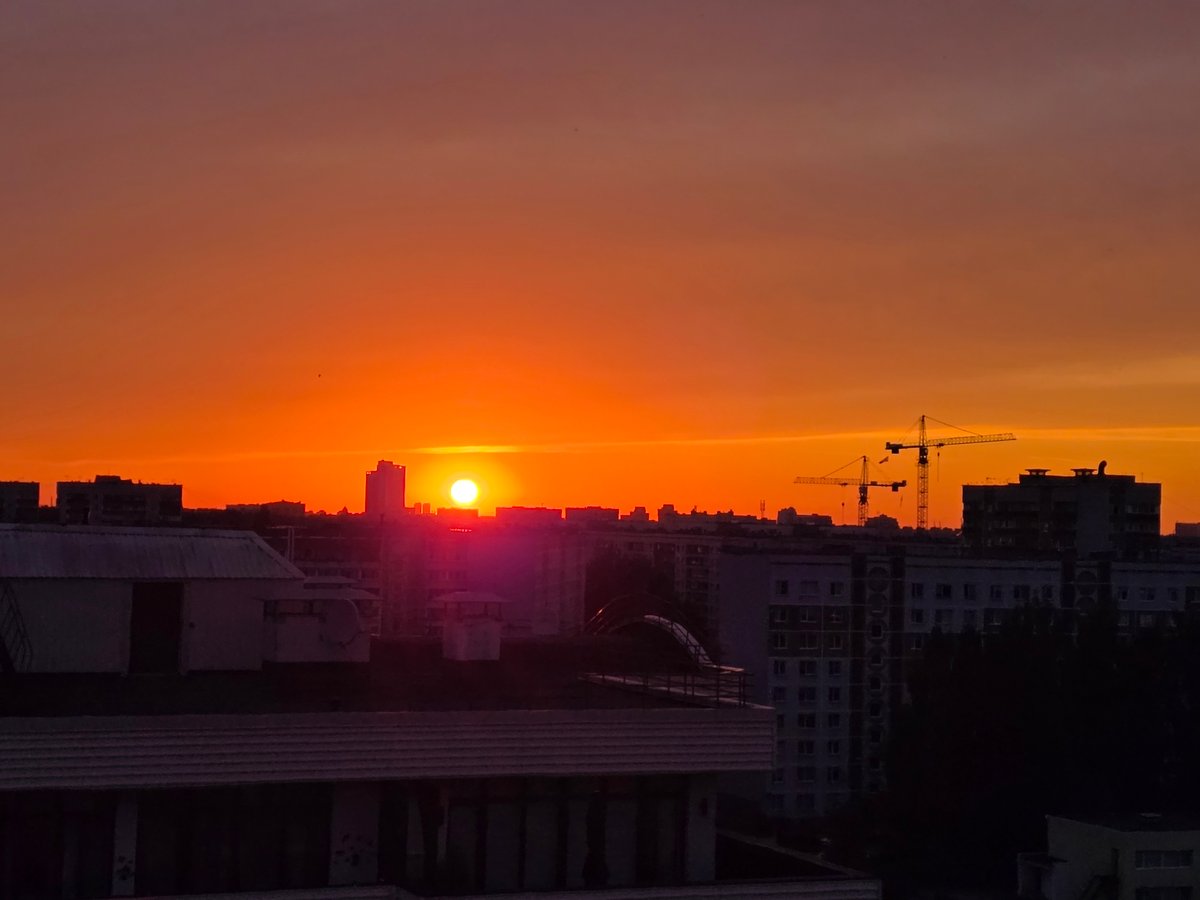 Riga skyline glows at sunset behind Soviet-era apartment blocks