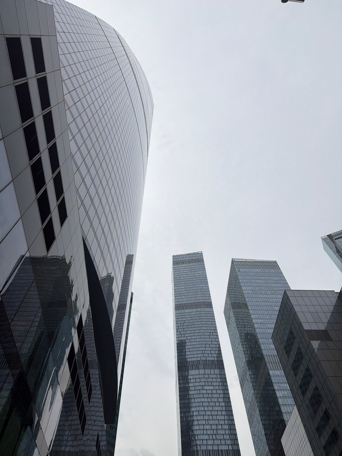 Street-level views of Moscow City's glass skyscrapers on a grey morning