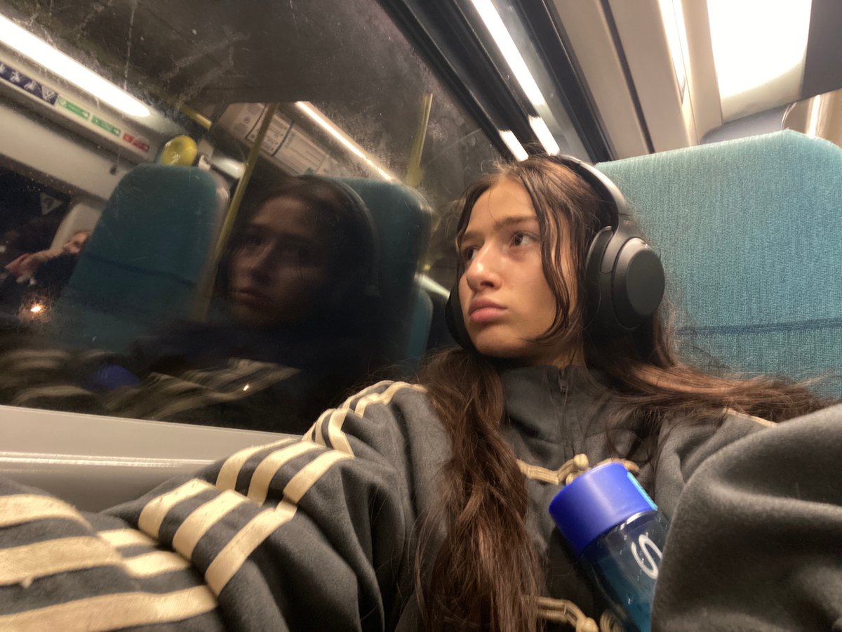 Woman rests against window during London transit journey