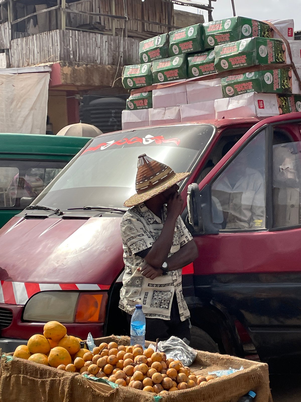 Person in straw hat observed near vehicle at market