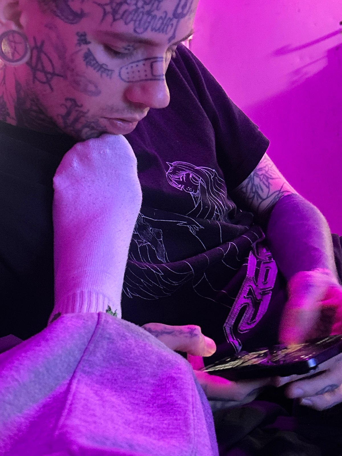 Tattooed person resting indoors, Fortnite gameplay captured in Buenos Aires