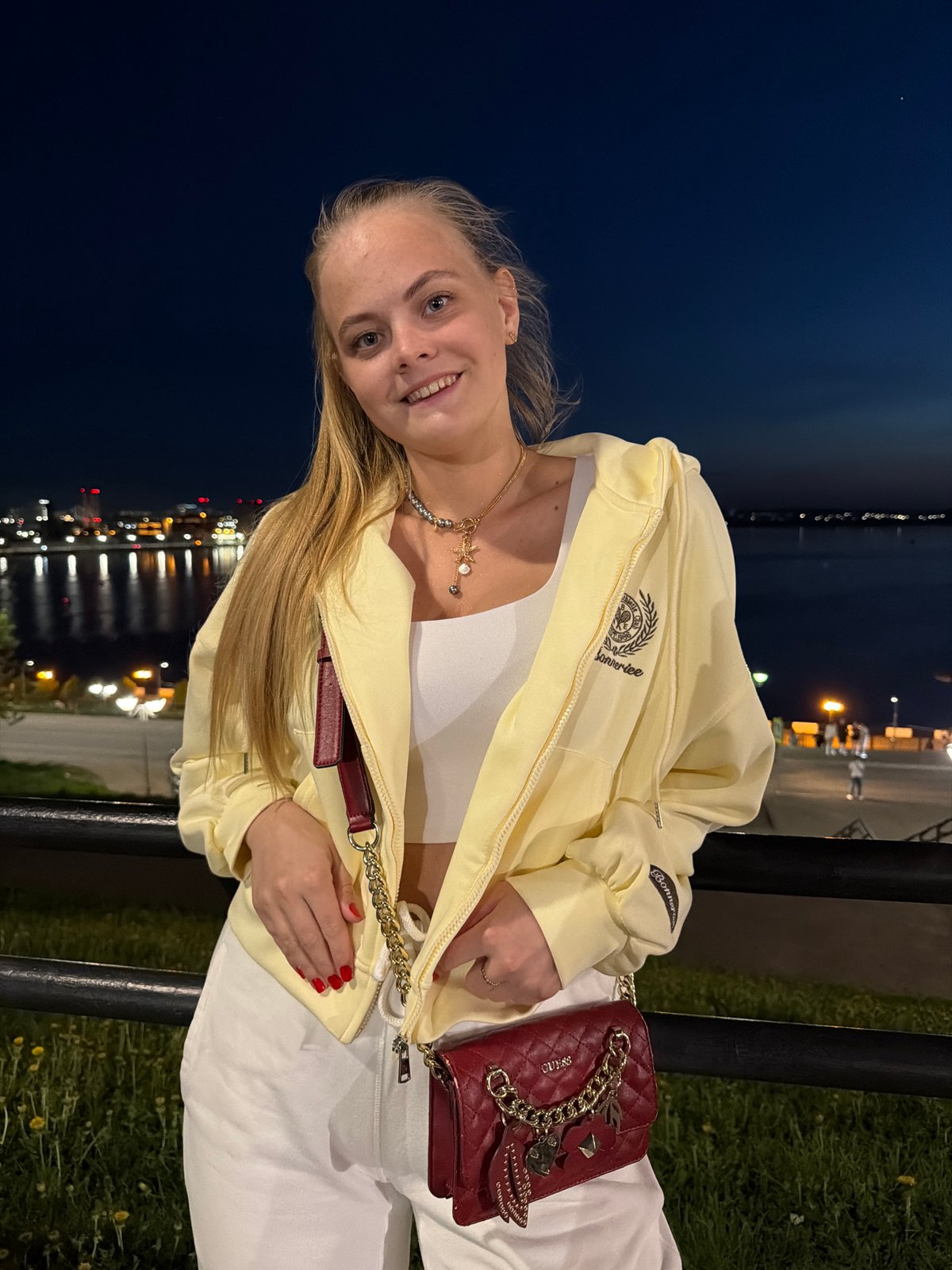 Woman observed at nighttime waterfront railing in Izhevsk, Russia